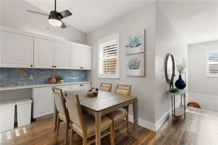 Dining space featuring dark wood finished floors, a ceiling fan, and vaulted ceiling