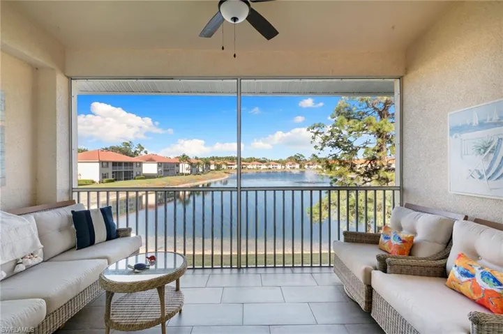 Sunroom / solarium with a textured wall and a water view