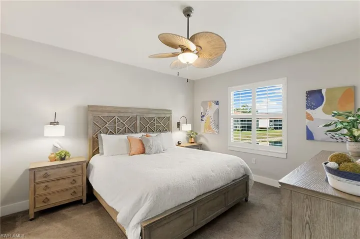 Bedroom with dark carpet and a ceiling fan
