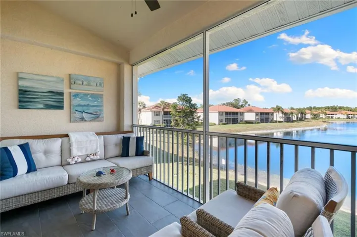 Balcony with a water view, outdoor seating, and ceiling fan