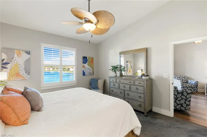 Bedroom with vaulted ceiling, ceiling fan, and dark colored carpet