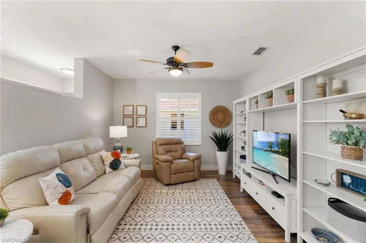 Living room featuring a ceiling fan and dark wood-style flooring