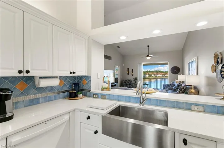 Kitchen featuring light stone counters, open floor plan, white cabinetry, white dishwasher, and recessed lighting