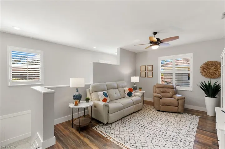 Living area with ceiling fan, dark wood-type flooring, and recessed lighting