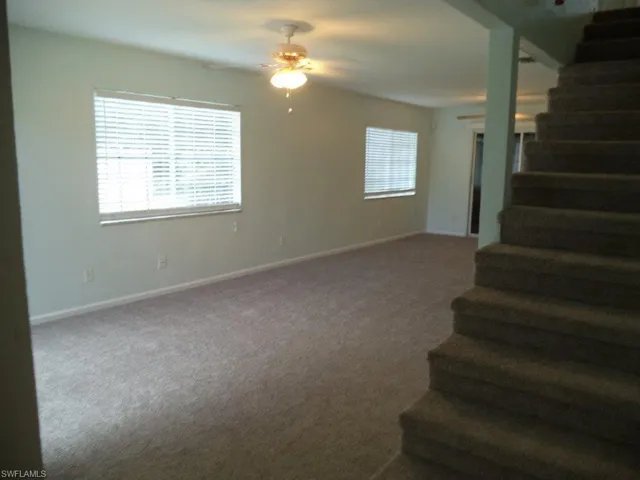 Staircase with carpet and a ceiling fan