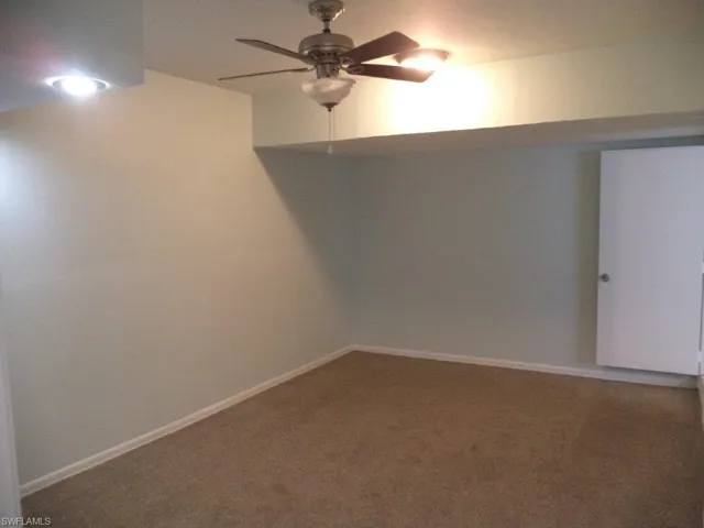 Spare room featuring carpet floors and a ceiling fan