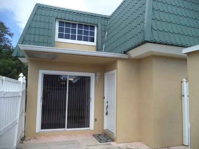Doorway to property featuring a tiled roof and stucco siding