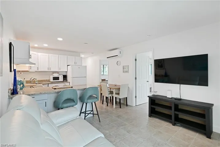 Living area with an AC wall unit and recessed lighting