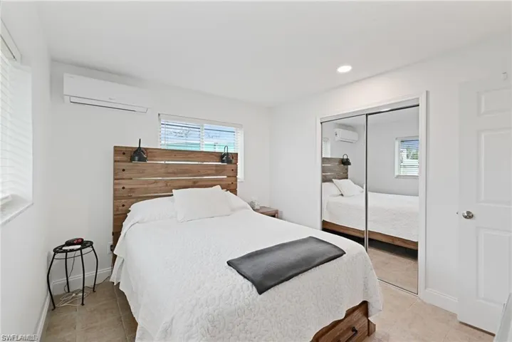 Bedroom with a wall mounted air conditioner, light tile patterned flooring, a closet, recessed lighting, and a wall mounted AC