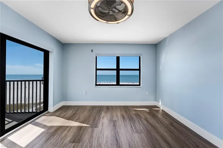 Master bedroom featuring dark wood-type flooring and a water view