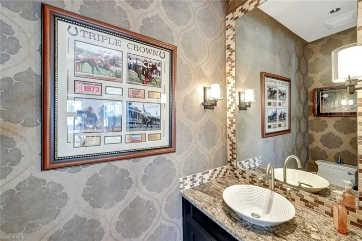 Half bath with vanity and wallpapered walls