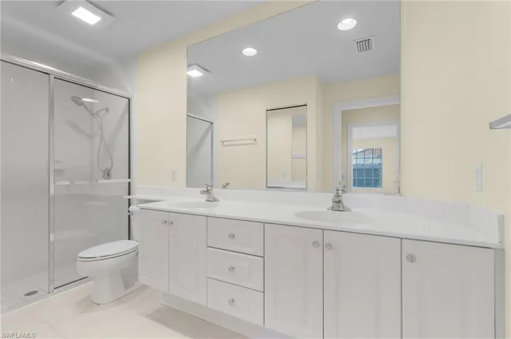 Bathroom with tile patterned floors, vanity, toilet, and walk in shower