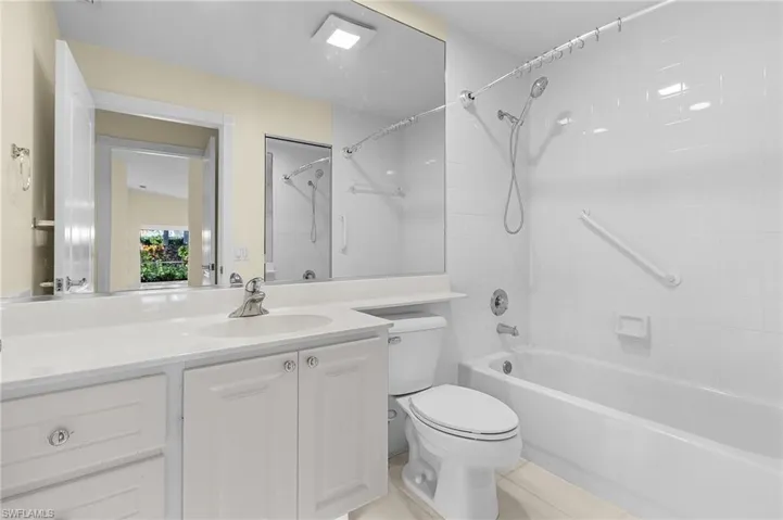 Full bathroom with vanity, tile patterned flooring, tiled shower / bath, and toilet