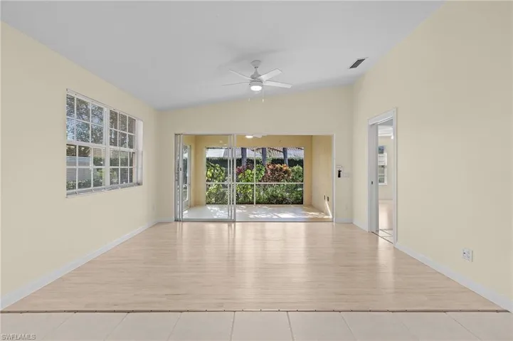 Unfurnished room featuring lofted ceiling, ceiling fan, and light wood-type flooring