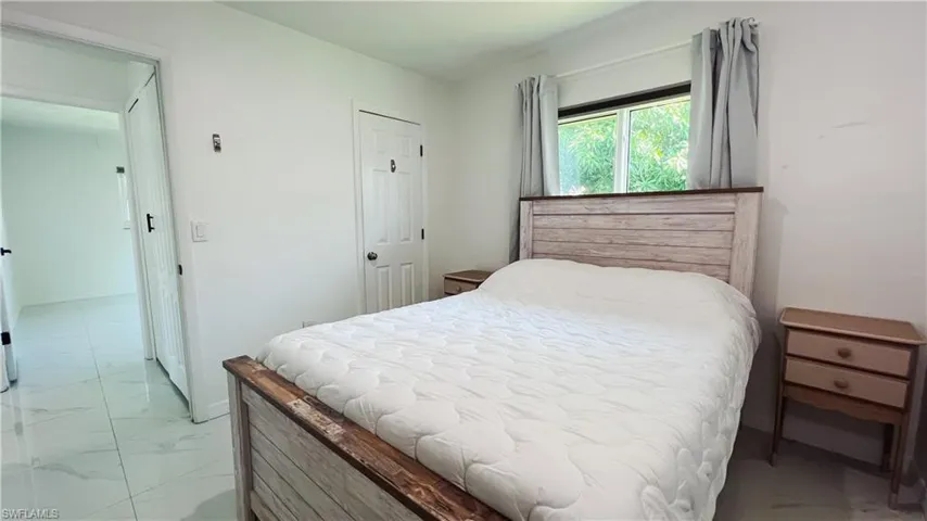 Bedroom with a closet and light marble finish floors