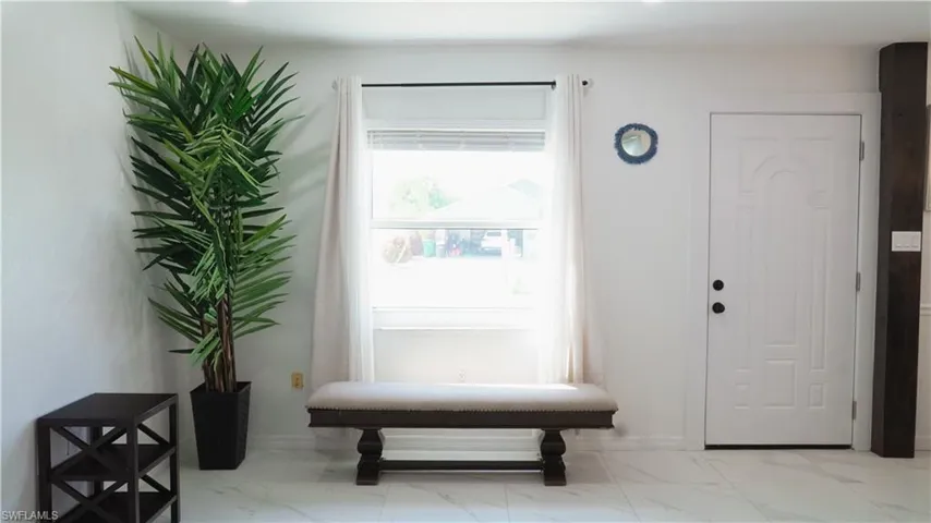 Entrance foyer with baseboards and light marble finish flooring