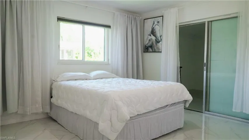 Bedroom featuring a closet and marble look tiles