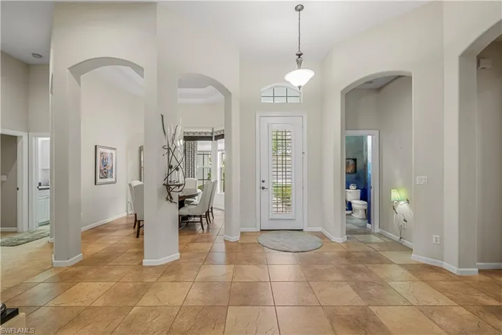 Tiled entryway with a towering ceiling