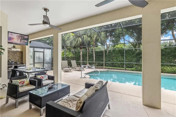 View of swimming pool featuring a lanai, a patio area, and ceiling fan