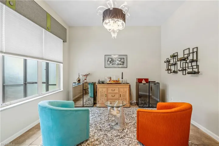 Den featuring tile patterned floors and an inviting chandelier