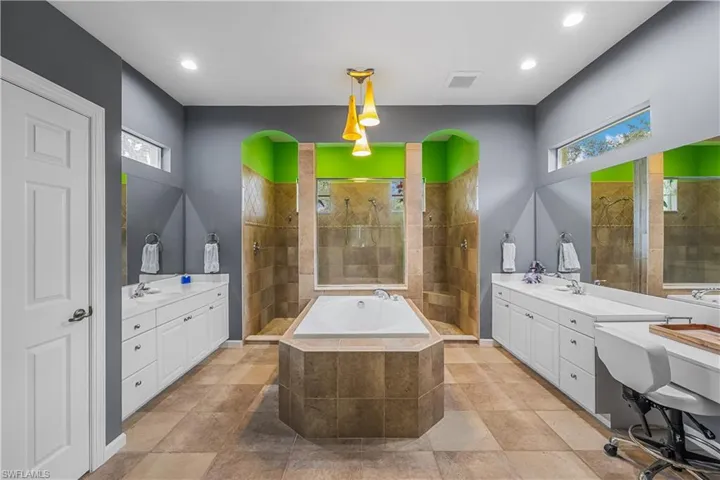 Bathroom with a healthy amount of sunlight, tile patterned floors, plus walk in shower, and double sink vanity