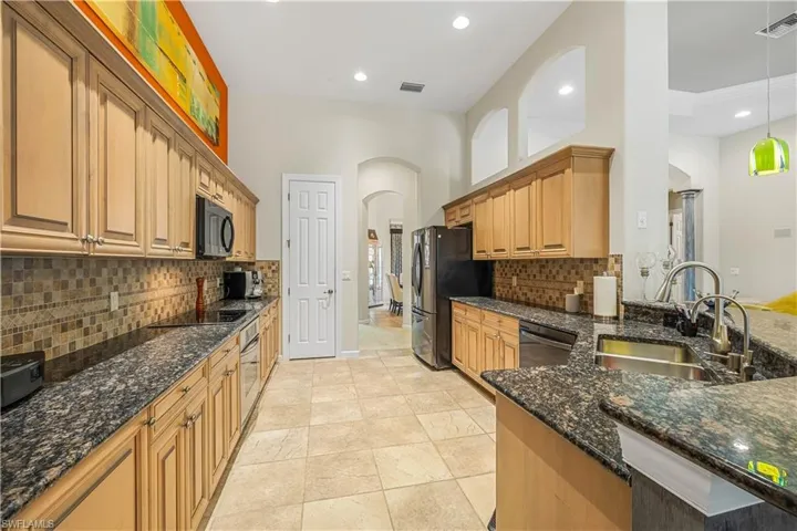 Kitchen featuring tasteful backsplash, stainless steel appliances, hanging light fixtures, sink, and  granite countertops