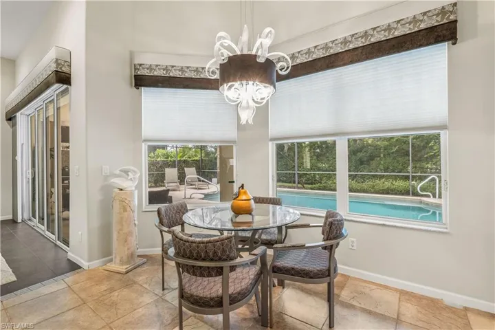 Tiled dining room featuring an inviting chandelier