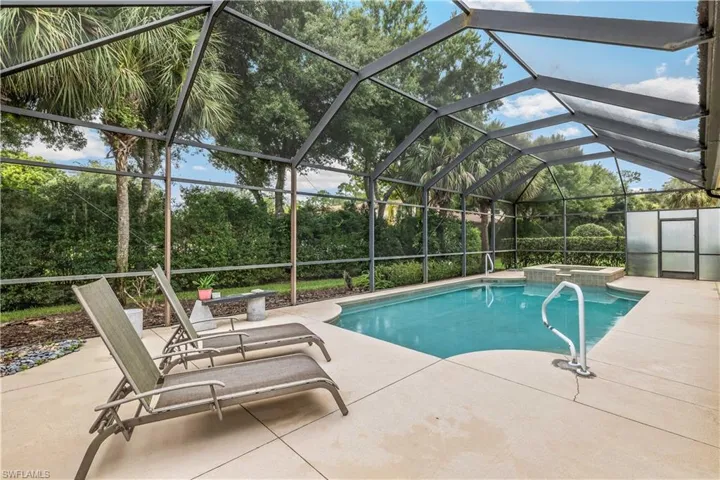 View of swimming pool with an in ground hot tub, a lanai, and a patio area