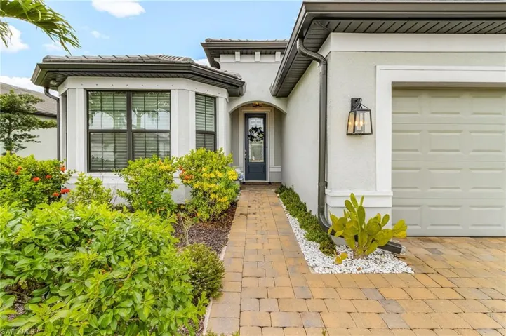 Entrance to property with stucco siding and an attached garage
