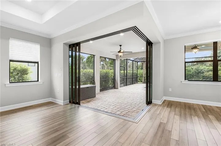 Bathroom featuring healthy amount of natural light, a shower stall, light tile patterned floors, and a ceiling fan