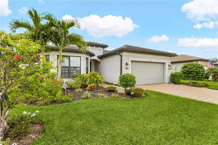 View of front of house featuring stucco siding, decorative driveway, a front yard, and a garage