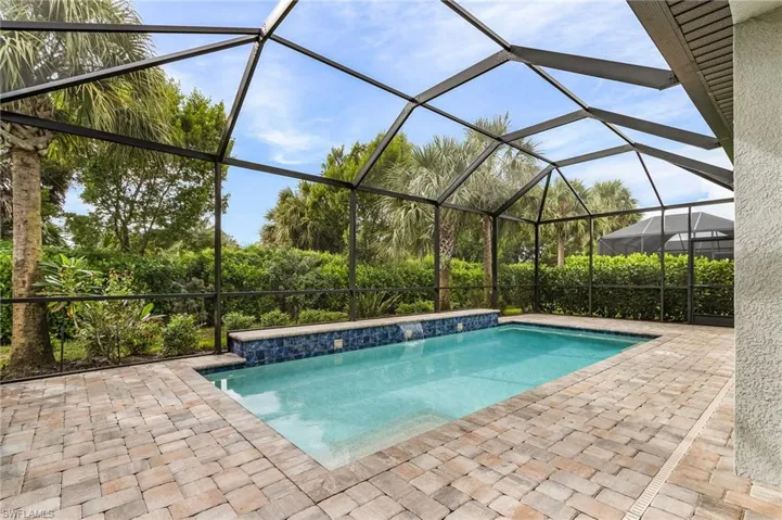 Swimming pool featuring a sunroom, glass enclosure, and a patio area