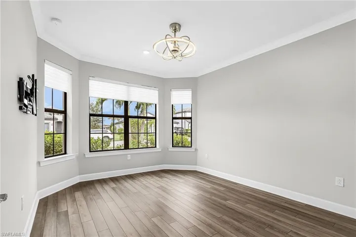 bedroom 1 featuring crown molding, wood finished floors, and a chandelier