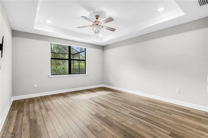 Bathroom featuring healthy amount of natural light, a shower stall, light tile patterned floors, and a ceiling fan