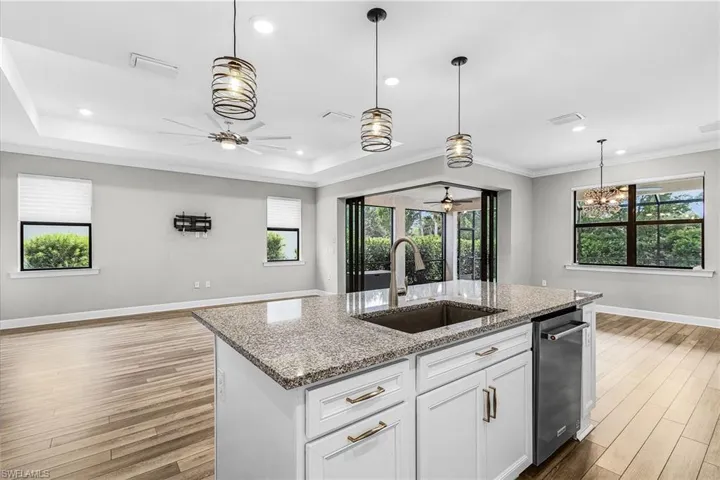 Kitchen with appliances with stainless steel finishes, white cabinetry, crown molding, decorative backsplash, and wall chimney exhaust hood