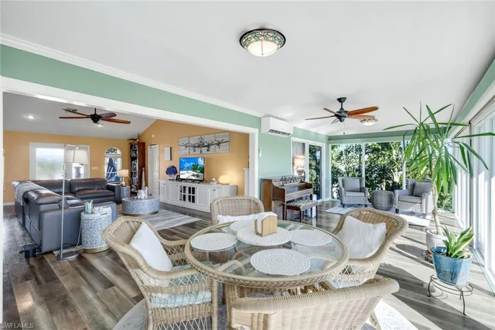 Dining space with a ceiling fan, plenty of natural light, wood finished floors, and lofted ceiling