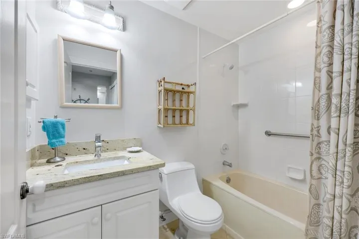 Guest bathroom with tub/shower combination, nice vanity with granite countertop and medicine cabinet.