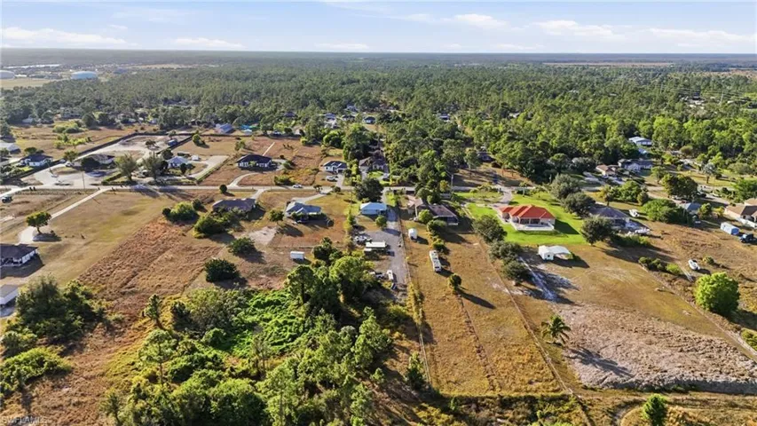 Aerial view of property's location featuring a heavily wooded area and nearby suburban area