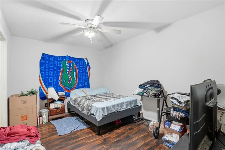 Bedroom with dark wood-style flooring and a ceiling fan
