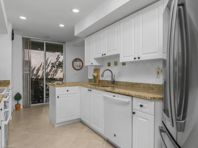 Kitchen with appliances, white cabinets, granite counters, and recessed lighting