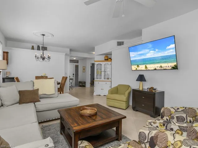 Living room featuring ceiling fan, hanging lights, and light tile flooring