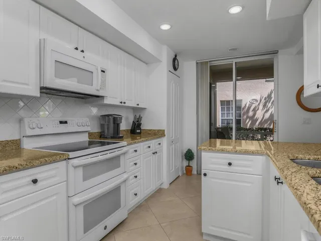 Kitchen featuring appliances, granite counters, white cabinets, tasteful backsplash, and recessed lighting
