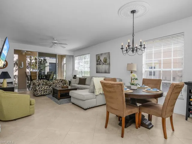 Dining area featuring ceiling fan, a chandelier, and light tile floors