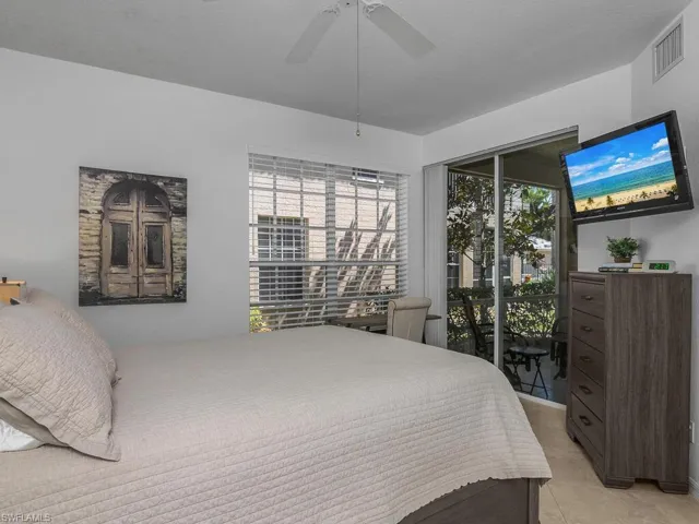 Bedroom with a ceiling fan and access to Lanai