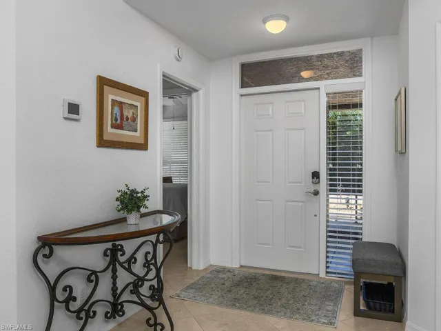 Foyer featuring light tile flooring and baseboards