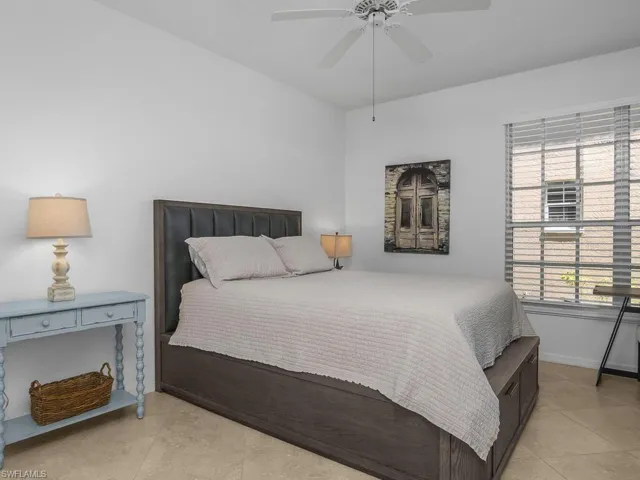 Bedroom with ceiling fan and light tile  floors