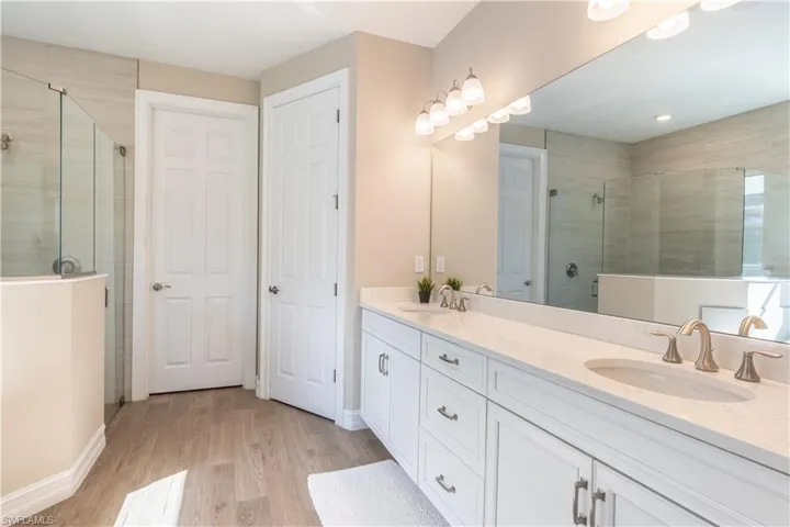 Bathroom with vanity, wood-type flooring, and an enclosed shower