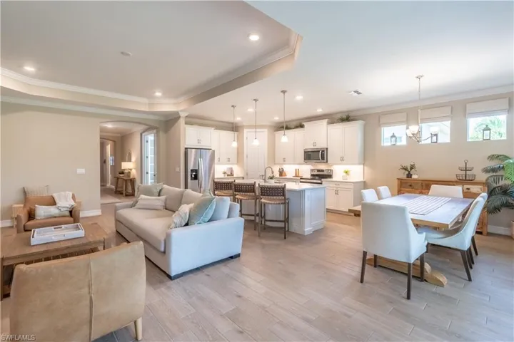 Living room featuring ornamental molding, a tray ceiling, and light wood-type flooring
