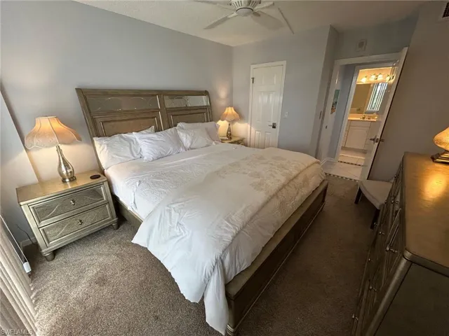 Bedroom featuring carpet, ensuite bathroom, and ceiling fan