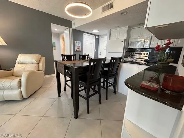 Dining space featuring a textured ceiling and light tile patterned flooring